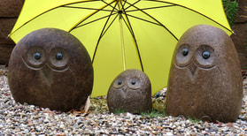 3 rock birds under a yellow umbrellaPicture